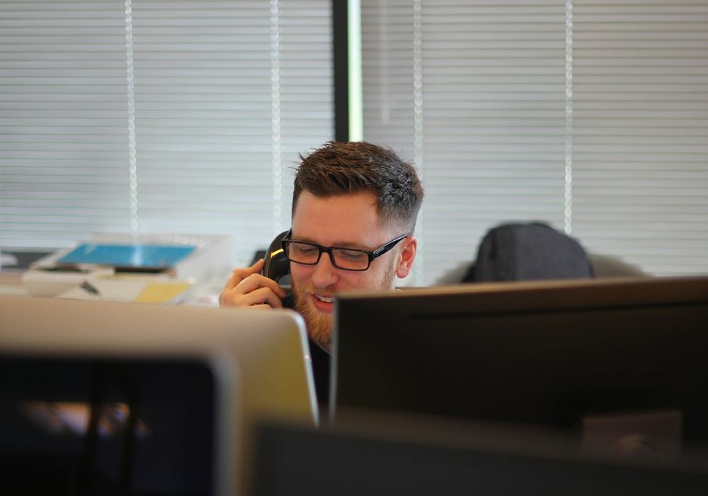 A support specialist on a call at his desk